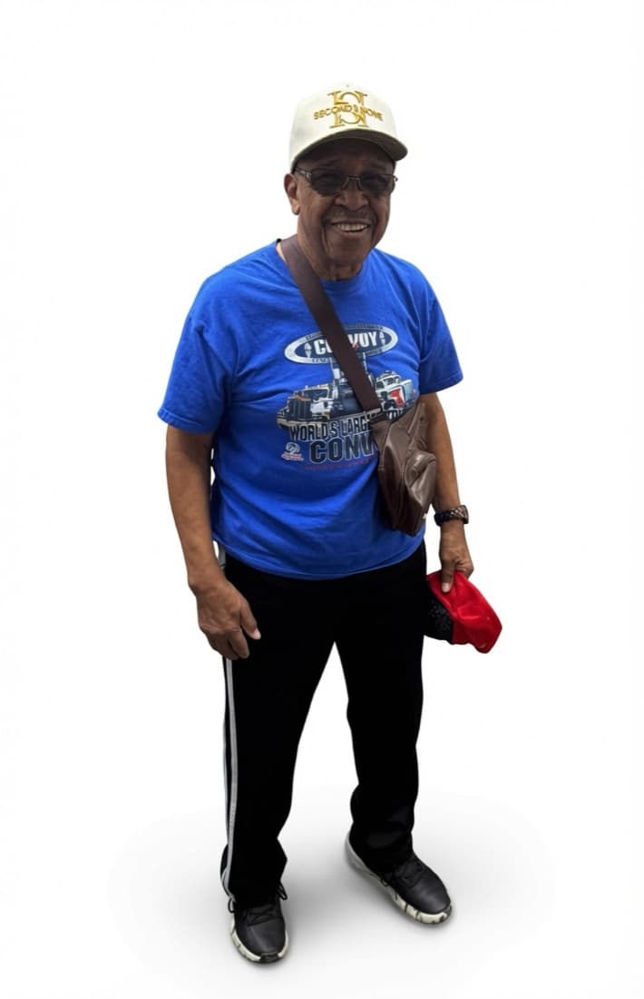 Smiling older adult in a blue graphic T-shirt wearing a cream Second II None cap