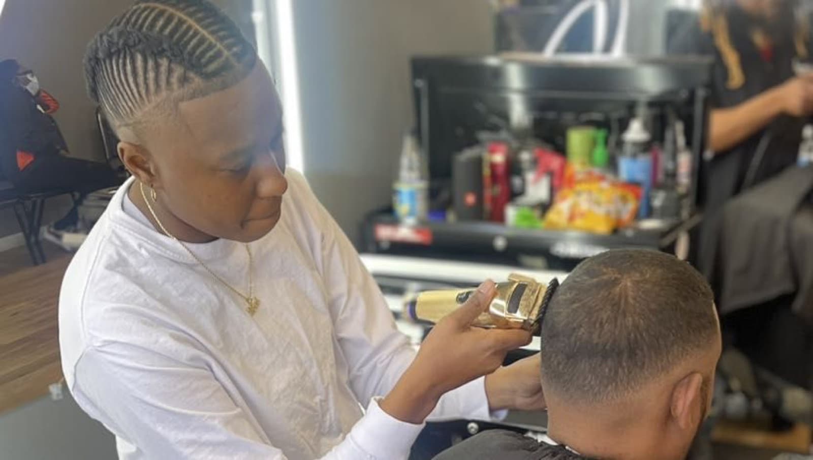 Free at work in her suite, mid-cut with the clippers on a client