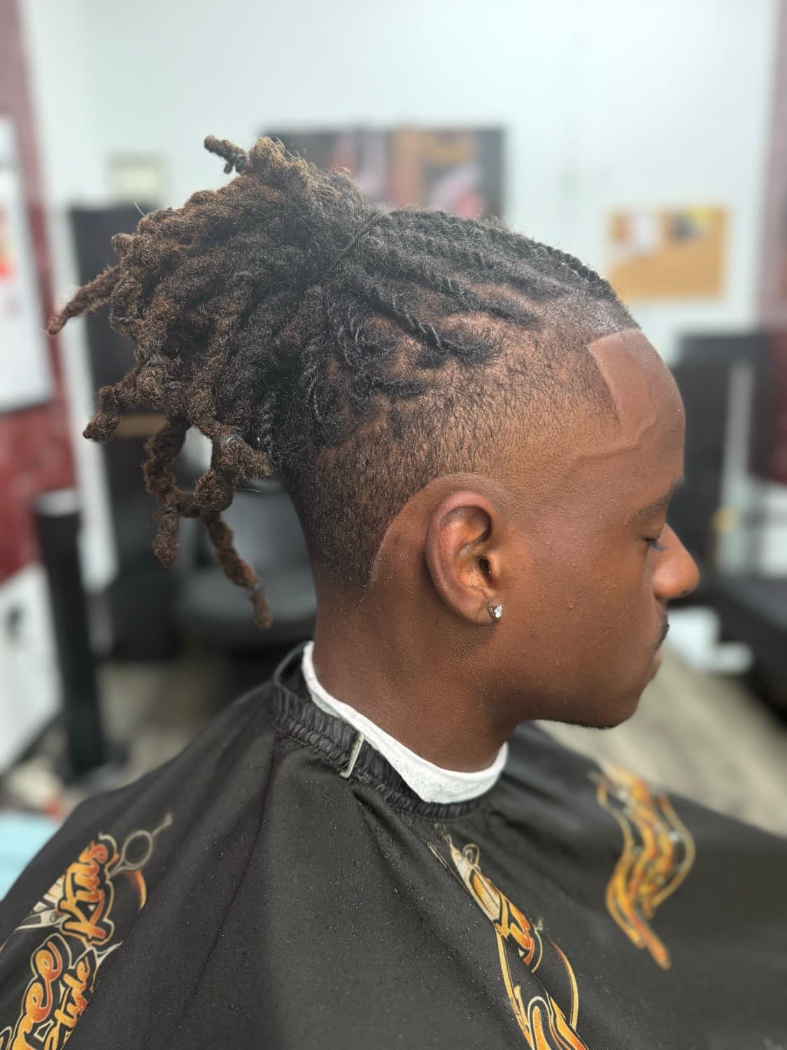 Locs styled into a mohawk over a burst fade