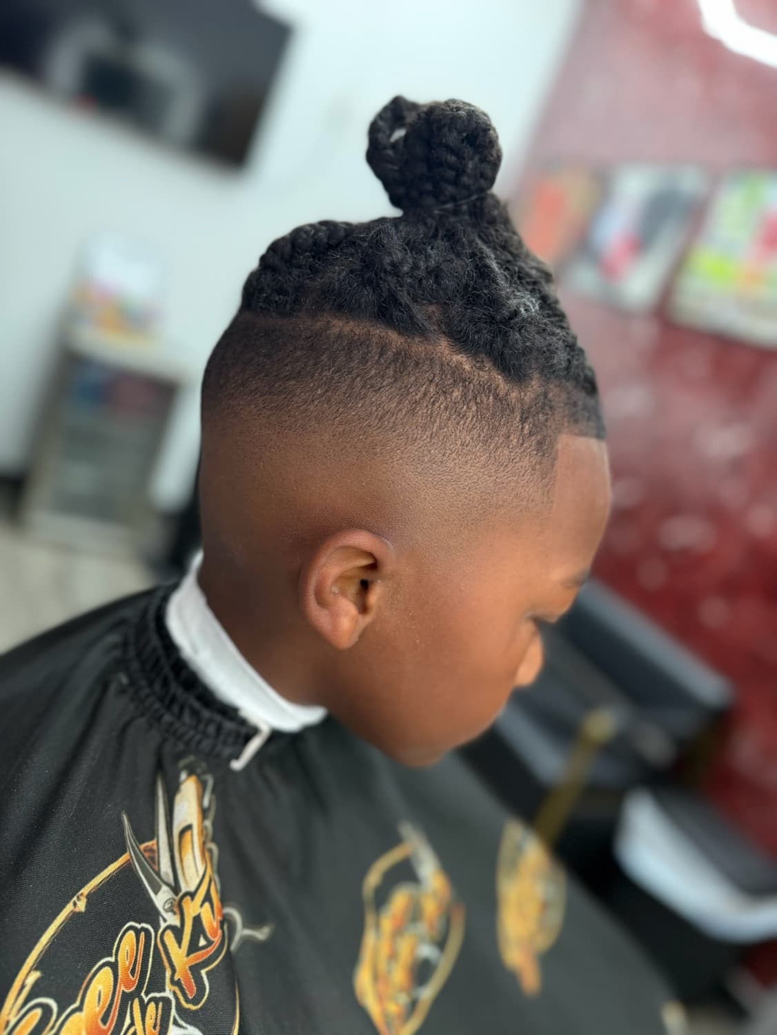 Youth locs pulled into a bun with a taper
